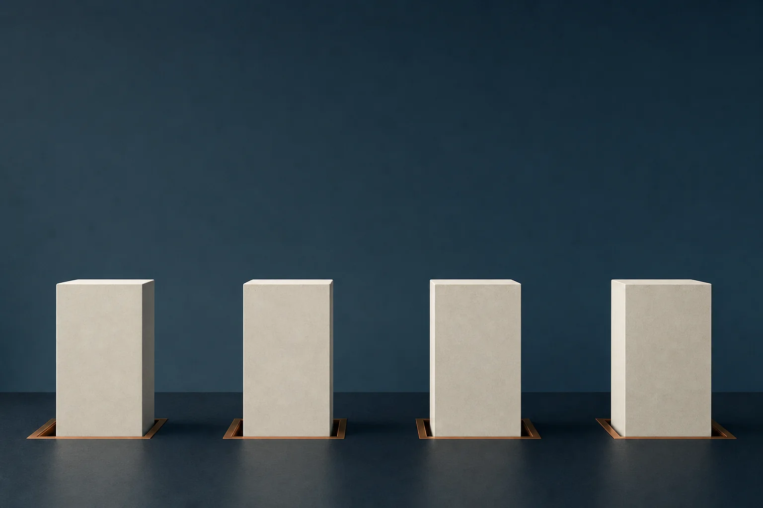 Four identical blank ivory blocks standing apart in a row on a navy floor, each seated in its own copper channel